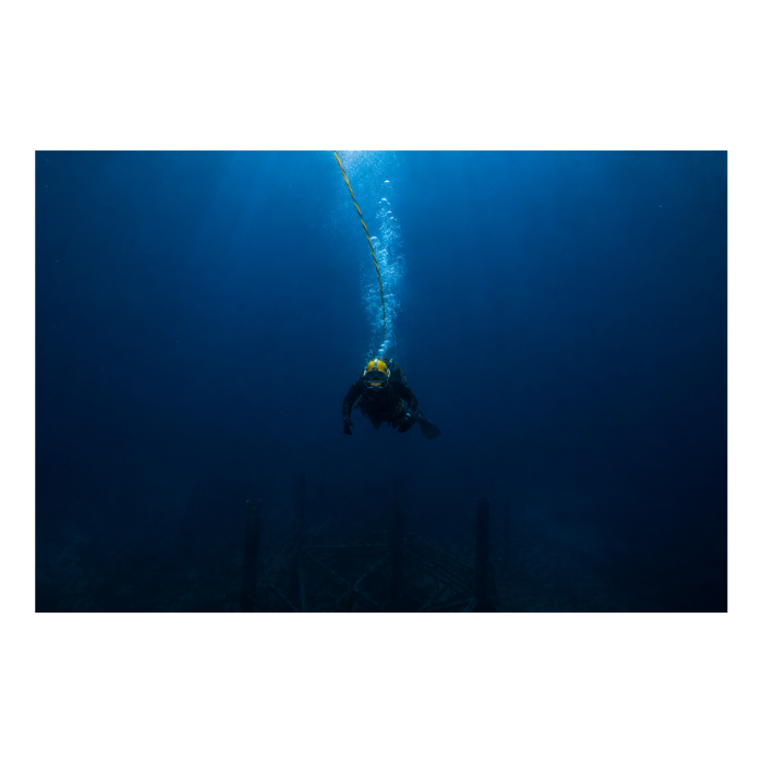 Scuba diver descending underwater on an offshore inspection dive